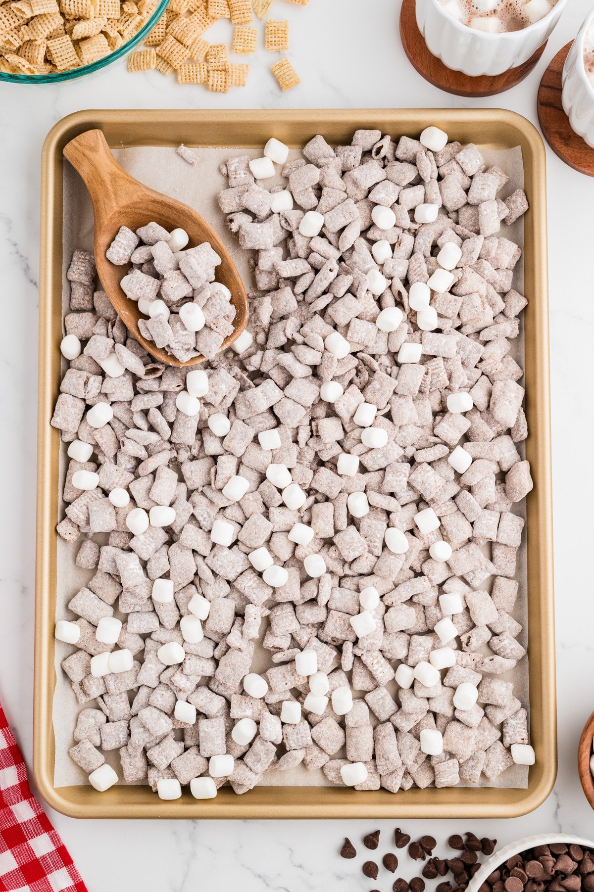 A baking sheet filled with Puppy Chow snack mix, with some mini marshmallows tossed in.
