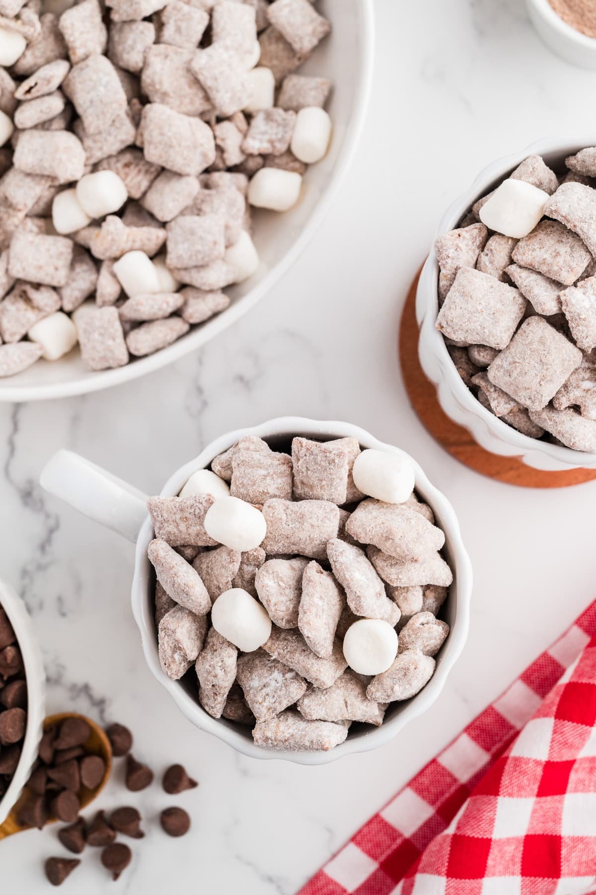 A mug full of muddy buddies, topped with a few marshmallows.