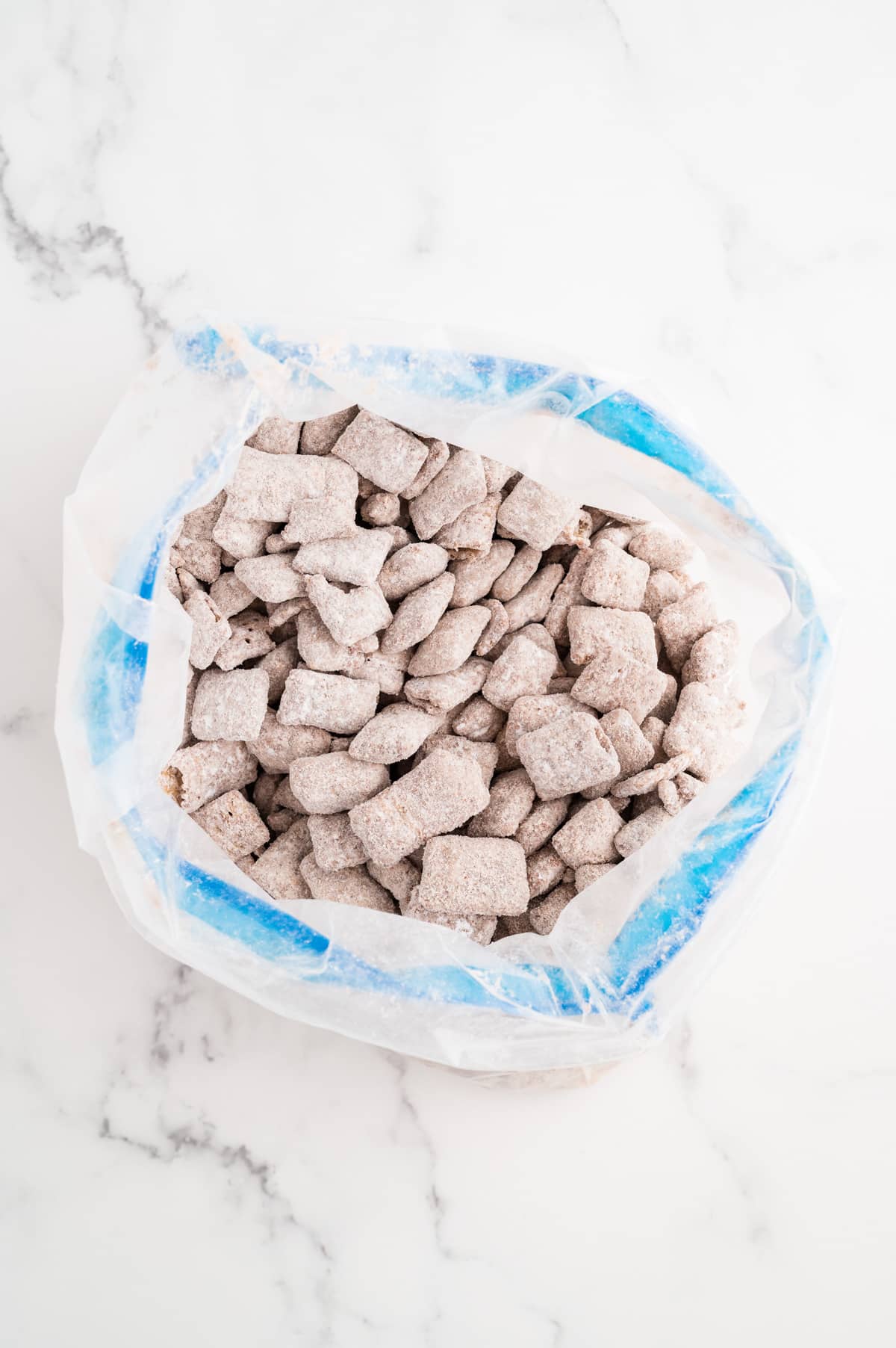 A freezer bag filled with Chex cereal coated in powdered sugar.