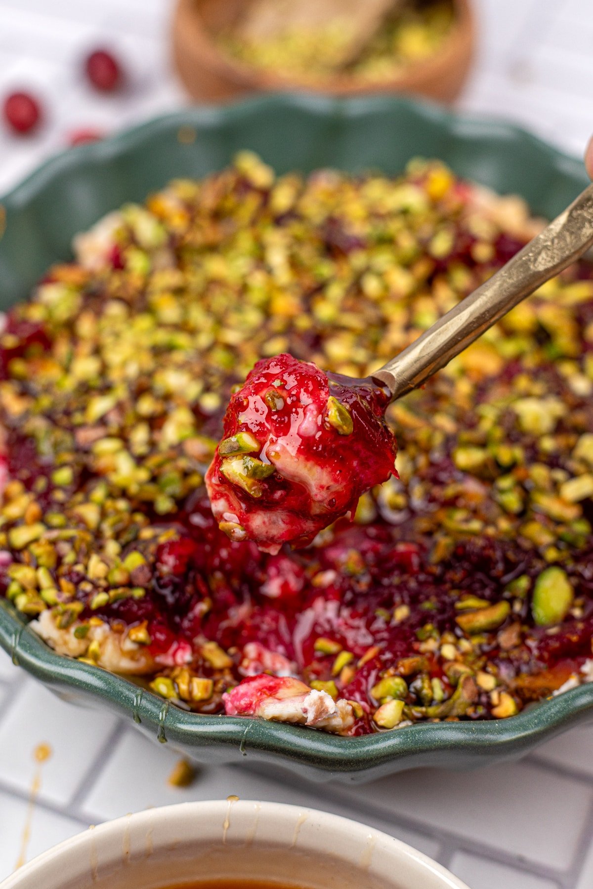 A spoonful of cranberry and boursin dip being taken from a serving bowl.
