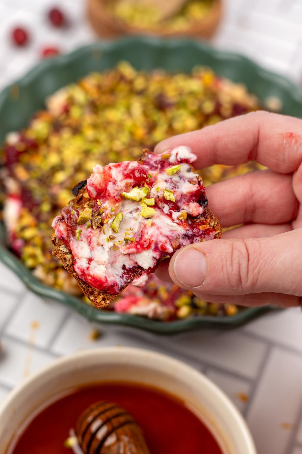 A fruit and nut cracker covered in boursin and cranberry sauce.