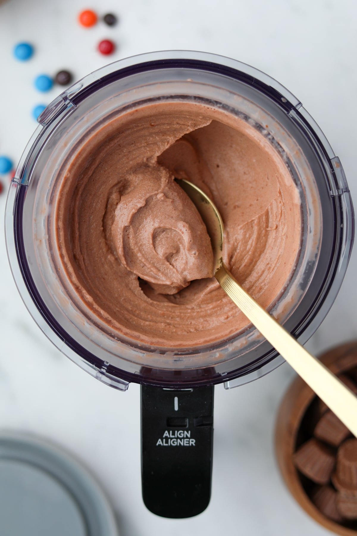 A ninja creami container insert, with soft chocolate ice cream being scooped.