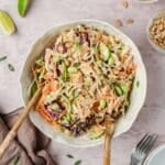 A bowl of bang bang chicken salad being tossed.