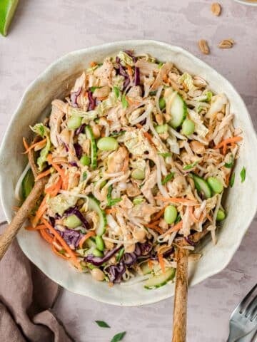 A bowl of bang bang chicken salad being tossed.
