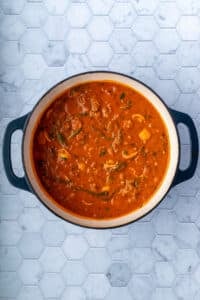 A pot of sausage and tortellini soup, ready to serve.