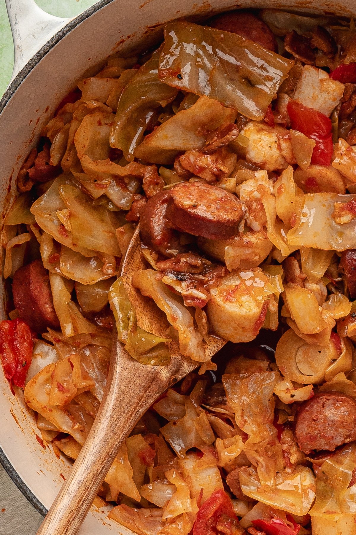 Scooping cabbage stew from a Dutch oven.
