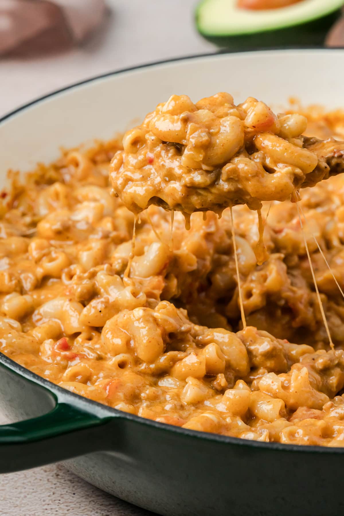 A spoonful of taco mac and cheese from a skillet.