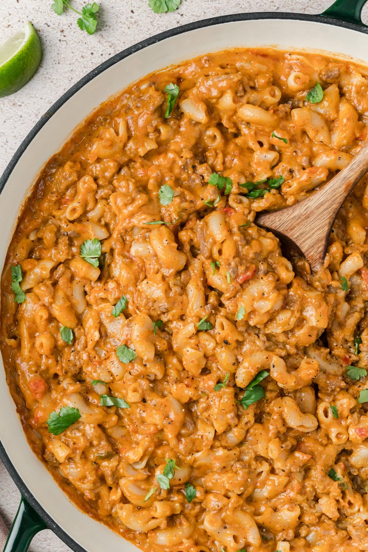 A skillet filled with taco macaroni and cheese garnished with cilantro.