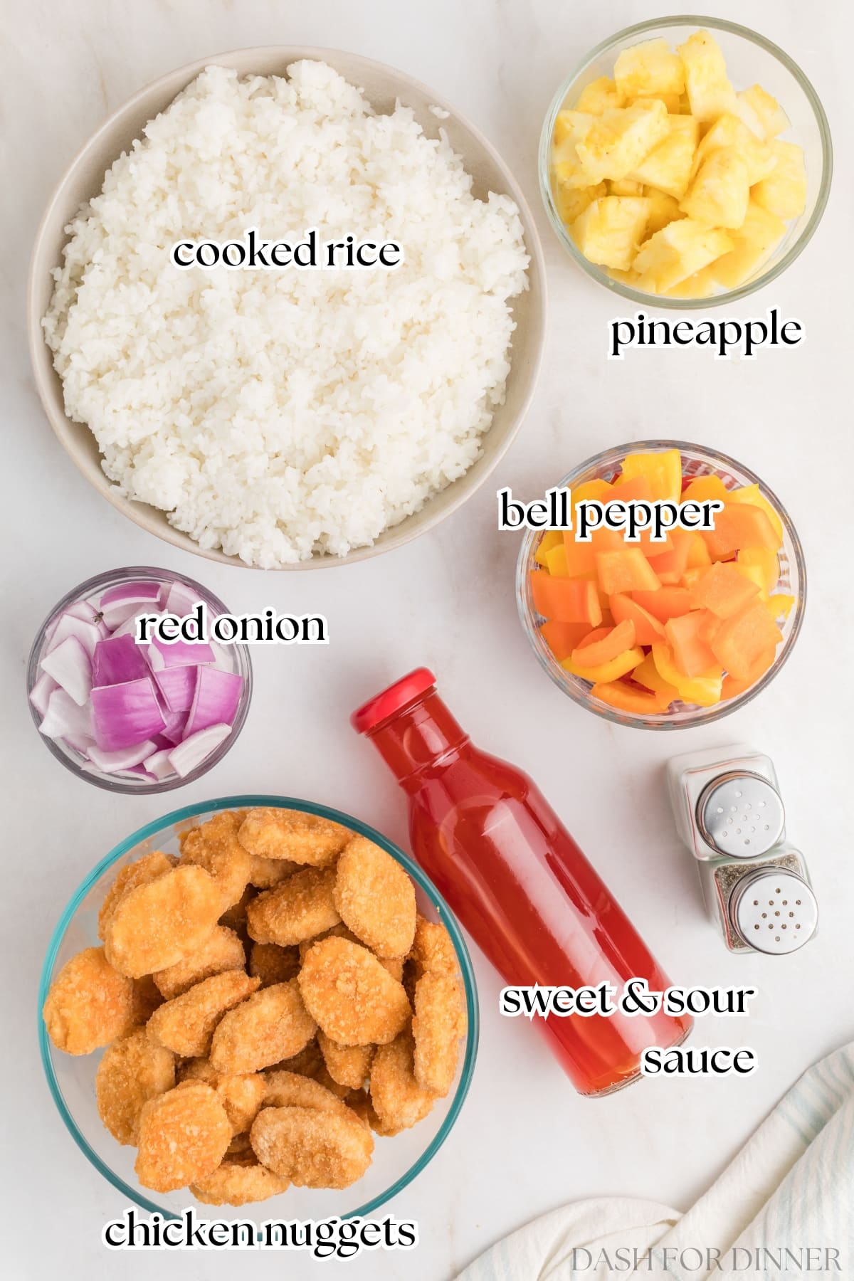 The ingredients needed to make cheater sweet and sour chicken, including chicken nuggets, rice, and pineapple.
