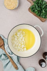 Adding onion to oil in a dutch oven.