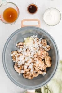 A skillet with onions and mushrooms.