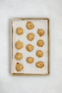 Cooked chicken meatballs on a baking sheet.