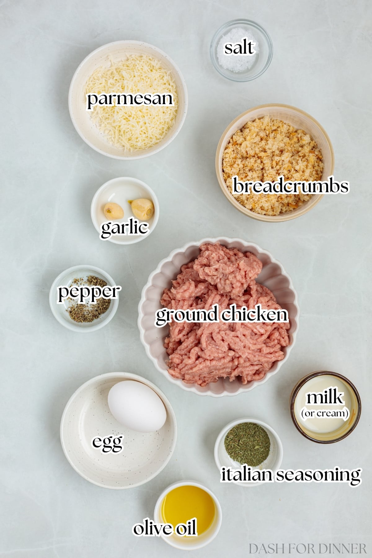 The ingredients needed to make chicken meatballs, including breadcrumbs, seasoning, olive oil, and parmesan cheese.