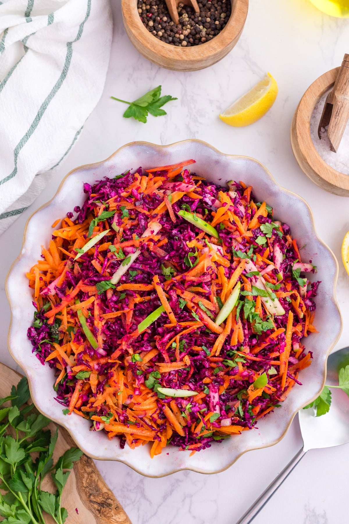 A bowl filled with shredded red cabbage, carrot, and green apple.