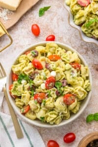 A bowl of pasta salad with tomatoes, basil, and mozzarella.