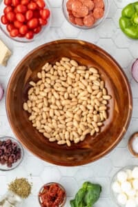 A wooden bowl filled with white beans.