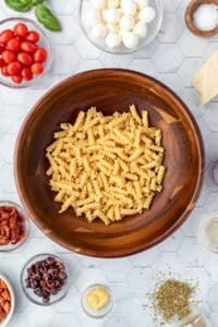 A salad bowl with cooked pasta in the center.