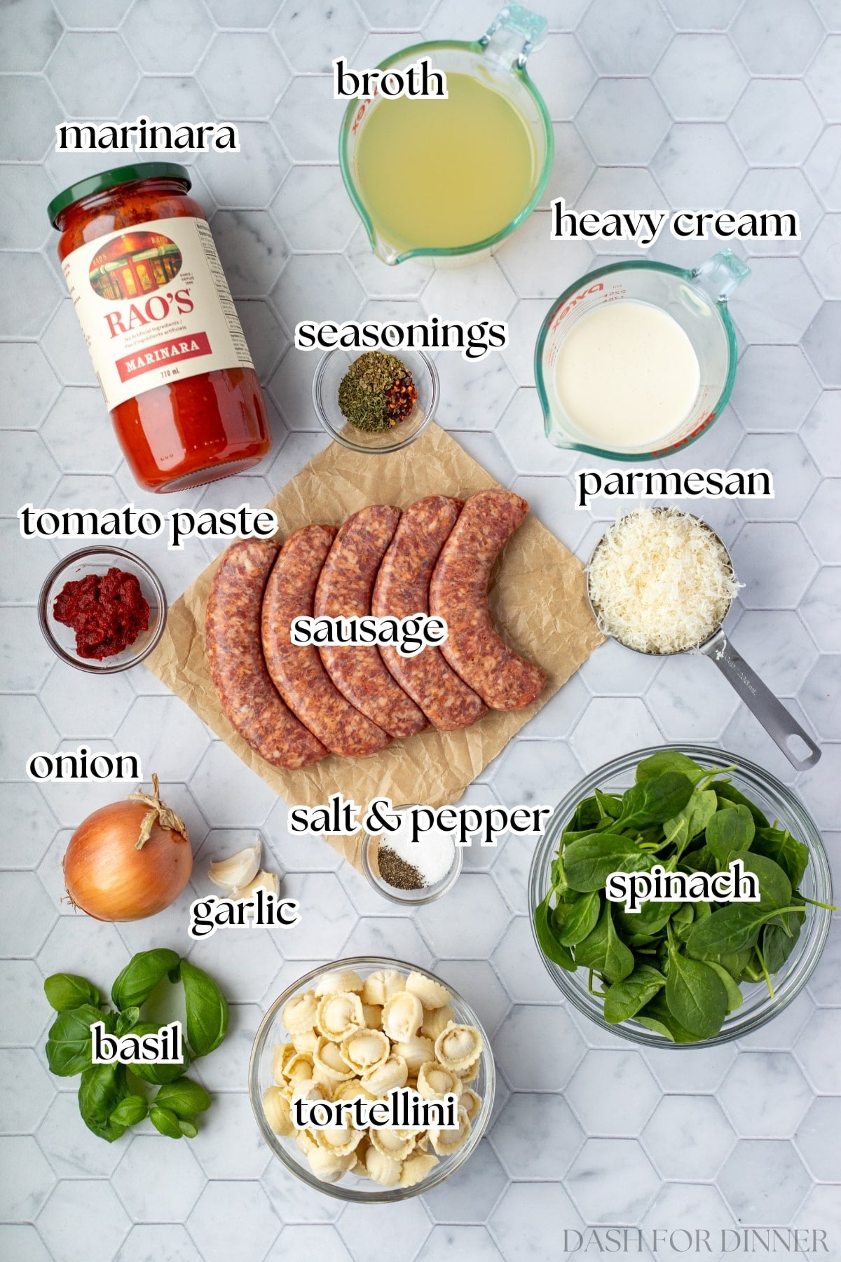 The ingredients needed to make tortellini sausage soup, including marinara sauce, sausage, and basil.