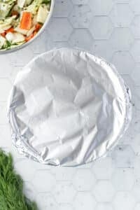 A bowl covered with foil.