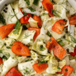 A salad with cabbage, red pepper, dill, and peppercorn.