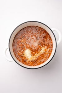 A soup pot with parmesan and cream poured into it.