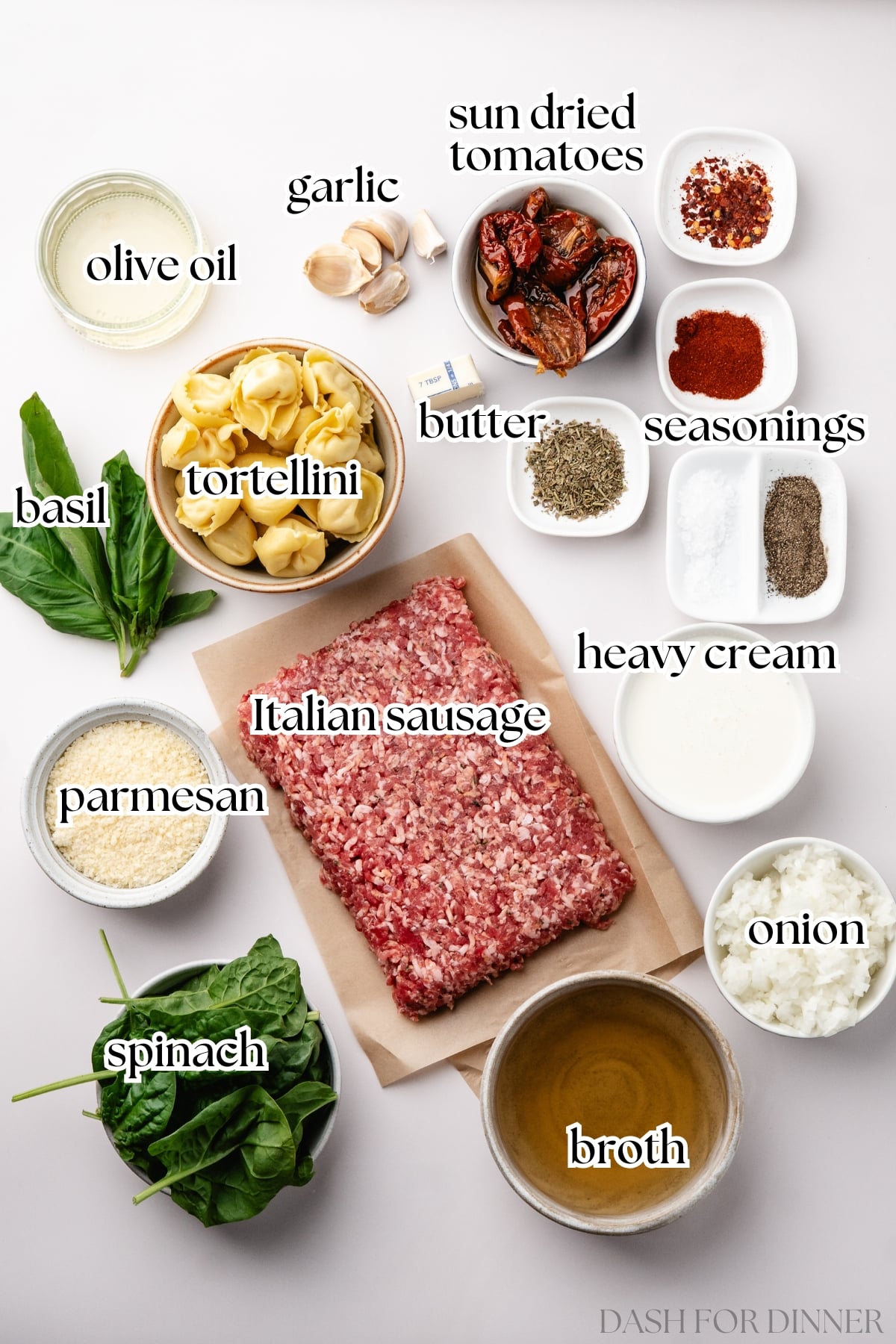 The ingredients needed to make tuscan soup, including Italian sausage, heavy cream, spinach, and broth.