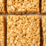 Rice krispie squares made with pumpkin spice laid flat on a surface.