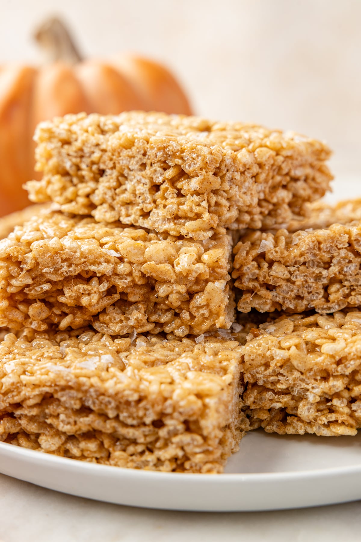 A stack of pumpkin cereal treats on a white plate.