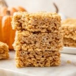 A stack of pumpkin rice krispie treats on a marble surface.