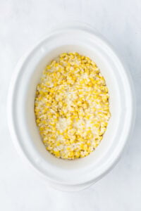 A slow cooker filled with cream cheese corn.